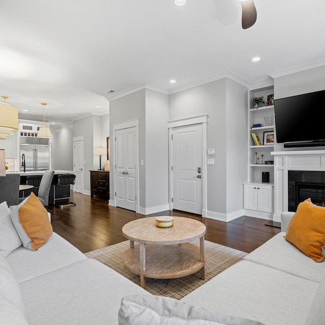 living room featuring dark hardwood / wood-style flooring, a high end fireplace, and ornamental molding