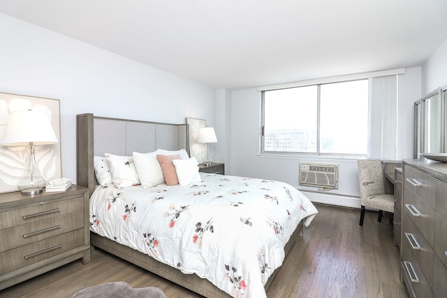 bedroom with dark hardwood / wood-style flooring, a wall mounted air conditioner, and a baseboard heating unit