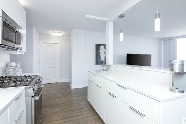 kitchen featuring white cabinetry, stainless steel appliances, decorative light fixtures, and dark wood-type flooring