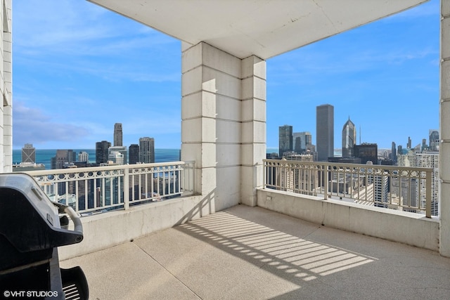 balcony featuring a skyline view and a water view
