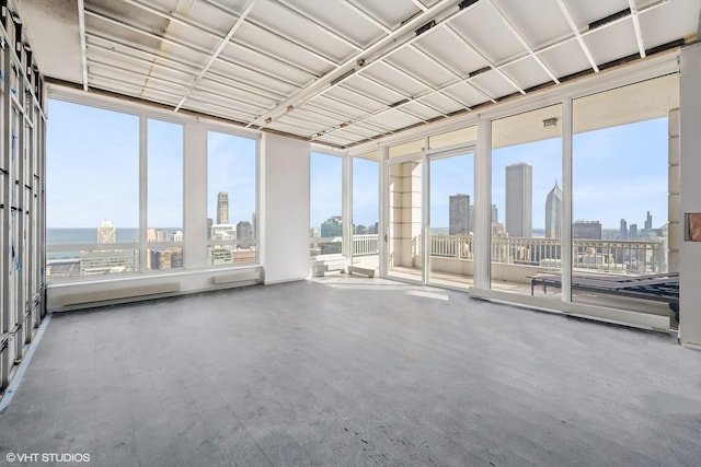 unfurnished sunroom featuring a view of skyline, wood finished floors, and plenty of natural light