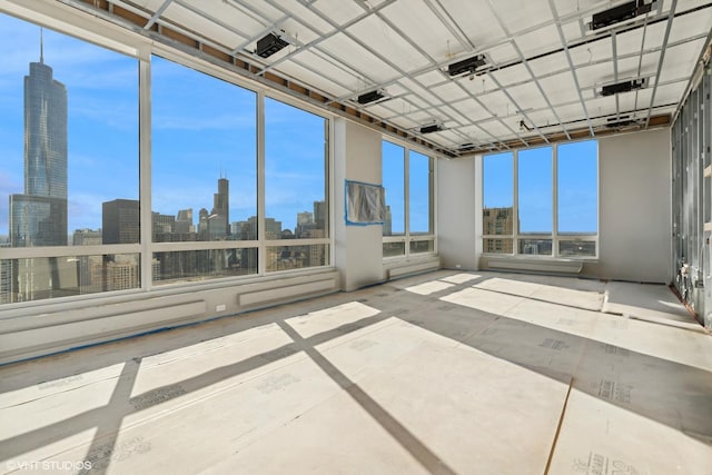 unfurnished sunroom featuring a skyline view and healthy amount of natural light