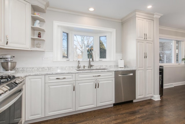 kitchen featuring a healthy amount of sunlight, appliances with stainless steel finishes, sink, and white cabinets