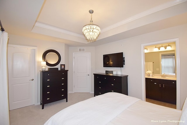 carpeted bedroom with sink, a chandelier, connected bathroom, and a tray ceiling