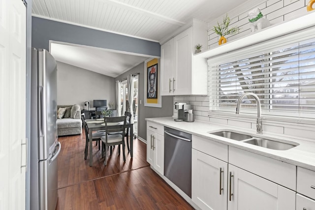 kitchen featuring appliances with stainless steel finishes, dark hardwood / wood-style floors, white cabinetry, sink, and decorative backsplash