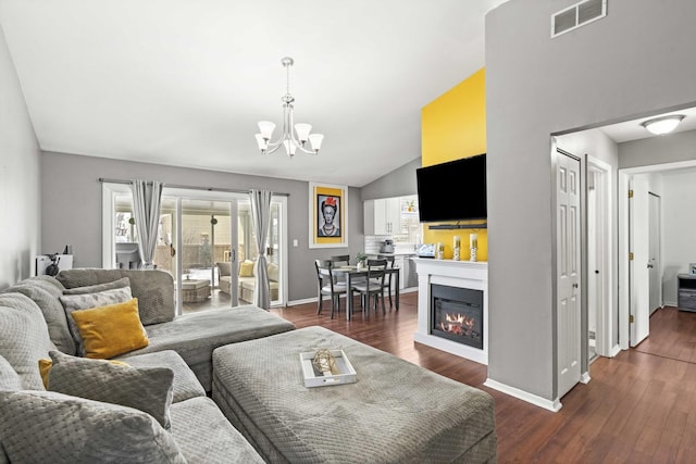 living room featuring lofted ceiling, a notable chandelier, and dark hardwood / wood-style flooring