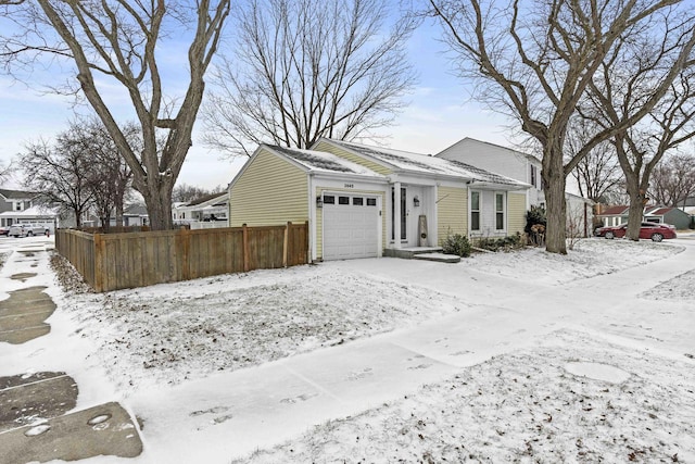 snow covered property with a garage