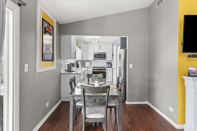 dining area with lofted ceiling, dark hardwood / wood-style floors, and sink