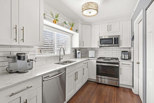 kitchen with white cabinetry, sink, light stone countertops, and appliances with stainless steel finishes