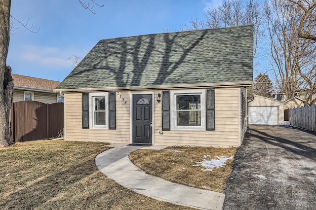 view of front of house with a front yard, an outbuilding, and a garage