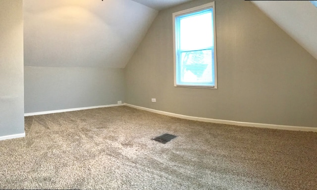 bonus room with a wealth of natural light, lofted ceiling, and carpet flooring