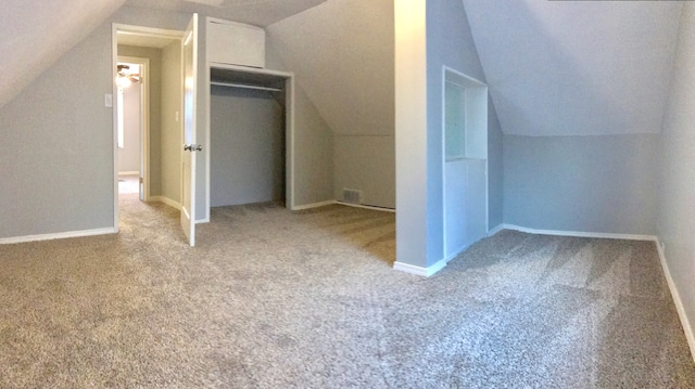 additional living space featuring vaulted ceiling and light colored carpet