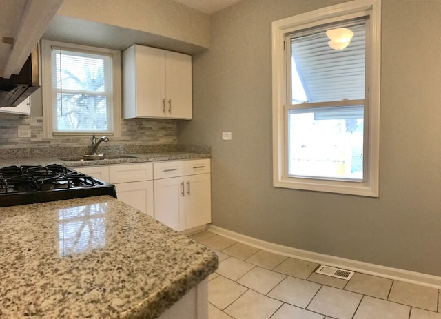 kitchen with white cabinets, backsplash, and sink