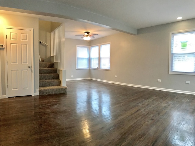 unfurnished room with beam ceiling, ceiling fan, and dark hardwood / wood-style flooring