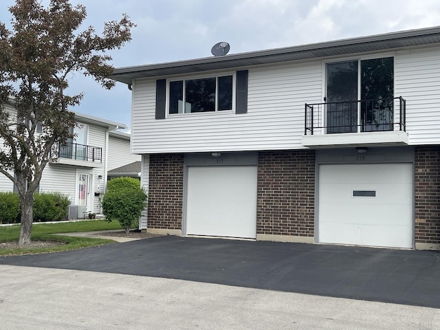 217 Kendrick Ct Unit 217, Schaumburg, IL 60194 - view of front of house featuring brick siding, a balcony, an attached garage, and driveway