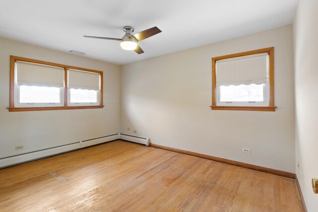 spare room featuring ceiling fan, light hardwood / wood-style flooring, and a baseboard heating unit