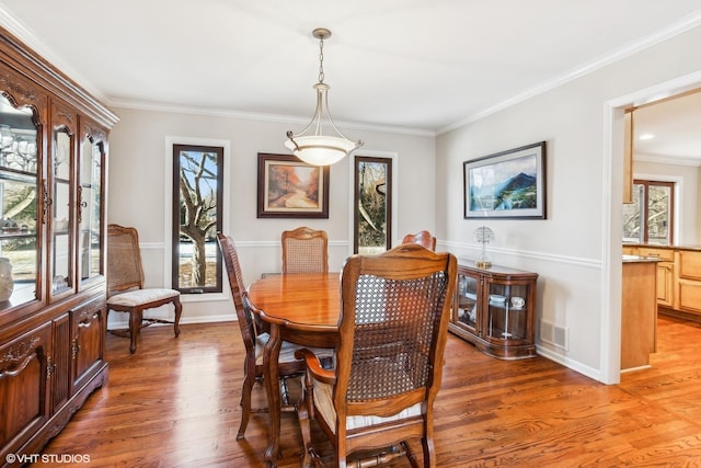 dining room with hardwood / wood-style flooring and crown molding