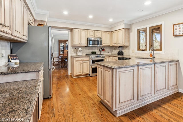 kitchen featuring light hardwood / wood-style flooring, sink, tasteful backsplash, dark stone counters, and stainless steel appliances