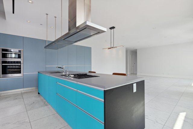 kitchen featuring a center island, island exhaust hood, blue cabinets, and double wall oven