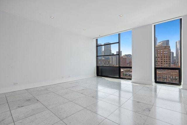 tiled empty room with floor to ceiling windows