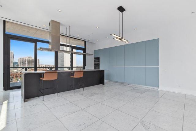 kitchen featuring a wall of windows and decorative light fixtures