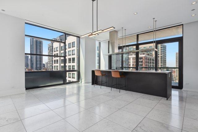 kitchen with light tile patterned floors, pendant lighting, and a wall of windows