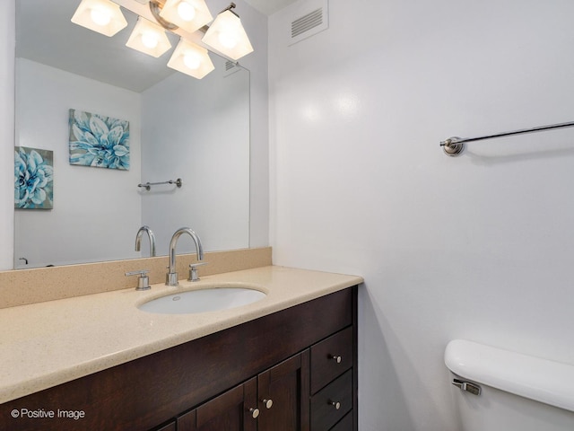 bathroom featuring toilet, visible vents, and vanity