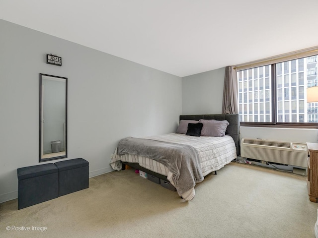 carpeted bedroom featuring a wall unit AC and baseboards