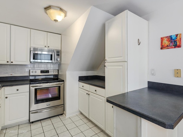 kitchen featuring dark countertops, tasteful backsplash, white cabinetry, and stainless steel appliances