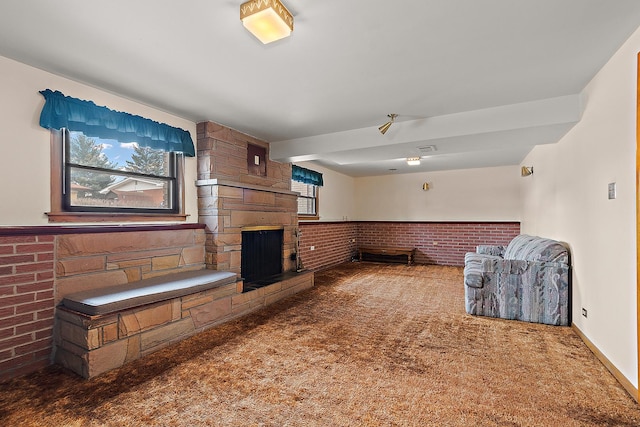 living room featuring a stone fireplace and carpet