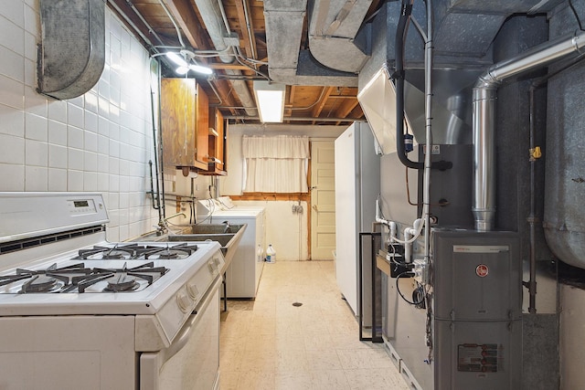 kitchen featuring sink, heating unit, gas range gas stove, and washer / clothes dryer