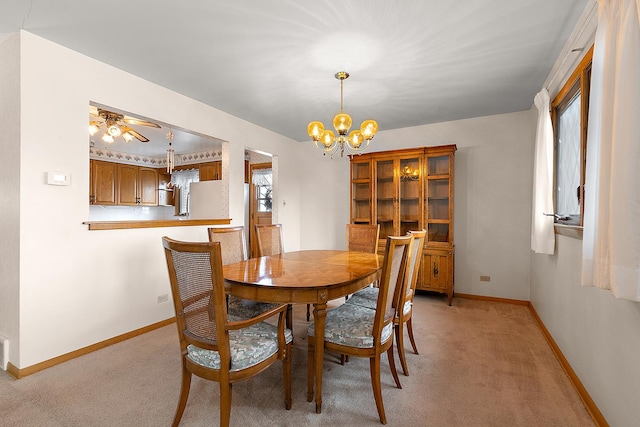 dining room with ceiling fan with notable chandelier and light colored carpet