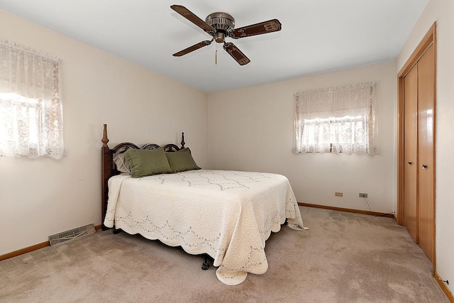 carpeted bedroom featuring ceiling fan and a closet