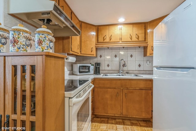 kitchen featuring white appliances, sink, decorative backsplash, and light parquet floors