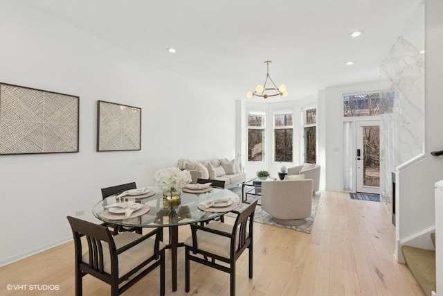 dining area with an inviting chandelier and light hardwood / wood-style floors