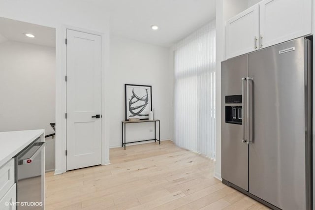 kitchen featuring white cabinetry, stainless steel appliances, and light wood-type flooring