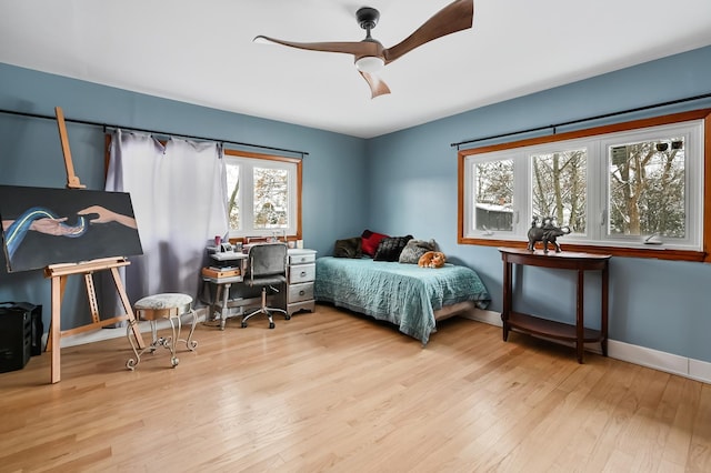 bedroom featuring light hardwood / wood-style floors, multiple windows, and ceiling fan