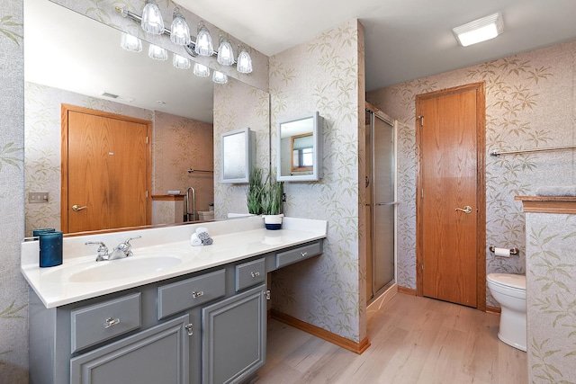 bathroom featuring hardwood / wood-style flooring, vanity, an enclosed shower, and toilet