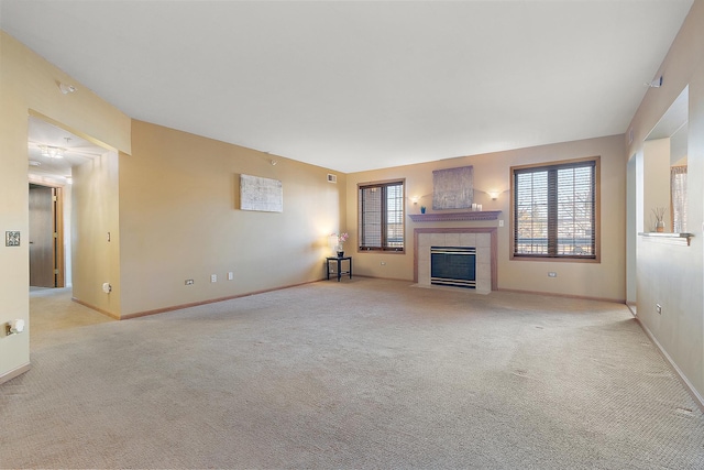 unfurnished living room with a tile fireplace and light carpet