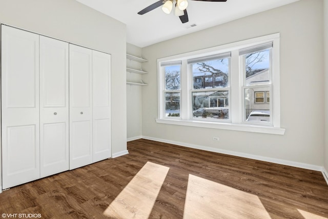 unfurnished bedroom featuring wood-type flooring, a closet, and ceiling fan