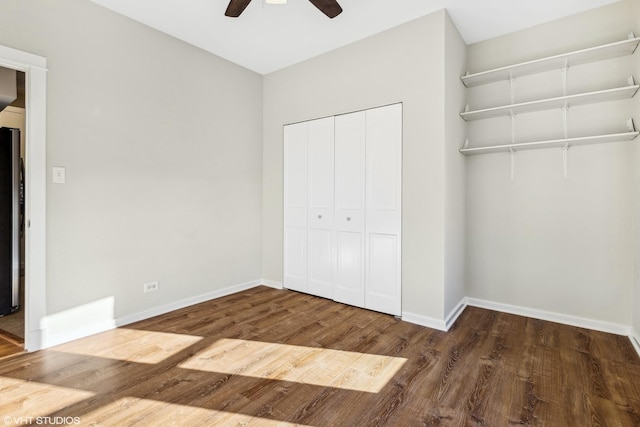 unfurnished bedroom featuring hardwood / wood-style flooring, ceiling fan, stainless steel fridge, and a closet