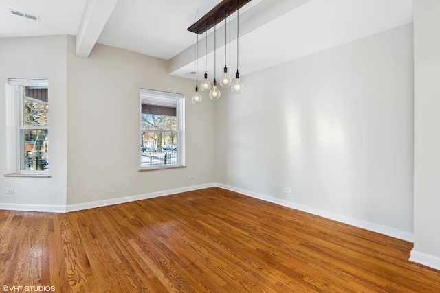 unfurnished dining area with hardwood / wood-style floors and vaulted ceiling with beams