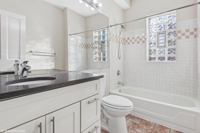 full bathroom with tiled shower / bath, vanity, toilet, and tile patterned flooring