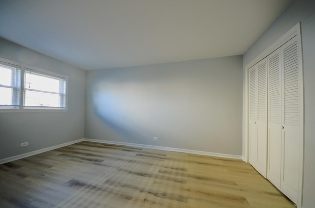 unfurnished bedroom featuring a closet and light wood-type flooring