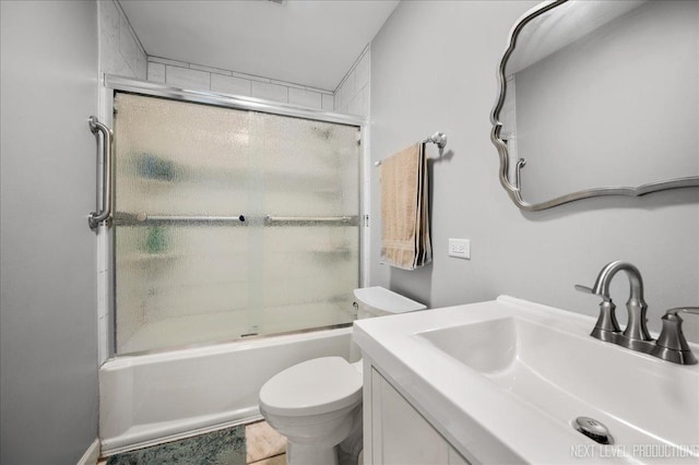 full bathroom featuring vanity, shower / bath combination with glass door, and toilet