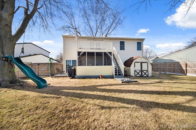 back of house with a yard, a playground, and a storage unit