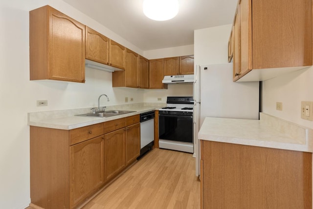 kitchen featuring sink, white appliances, and light wood-type flooring