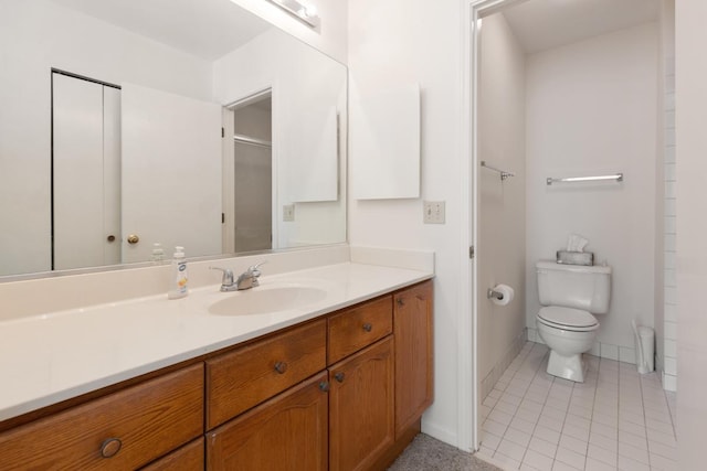 bathroom with vanity, walk in shower, tile patterned floors, and toilet