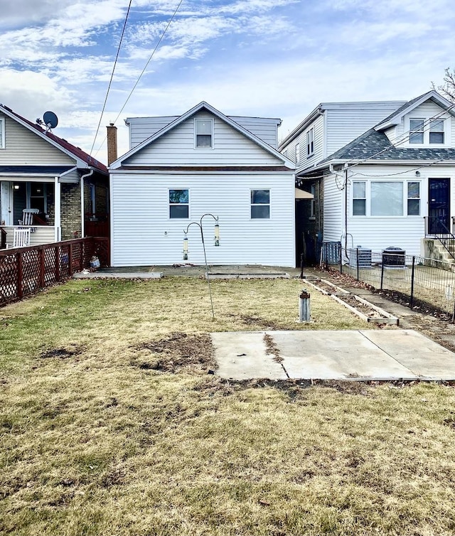 rear view of property featuring a patio and a lawn