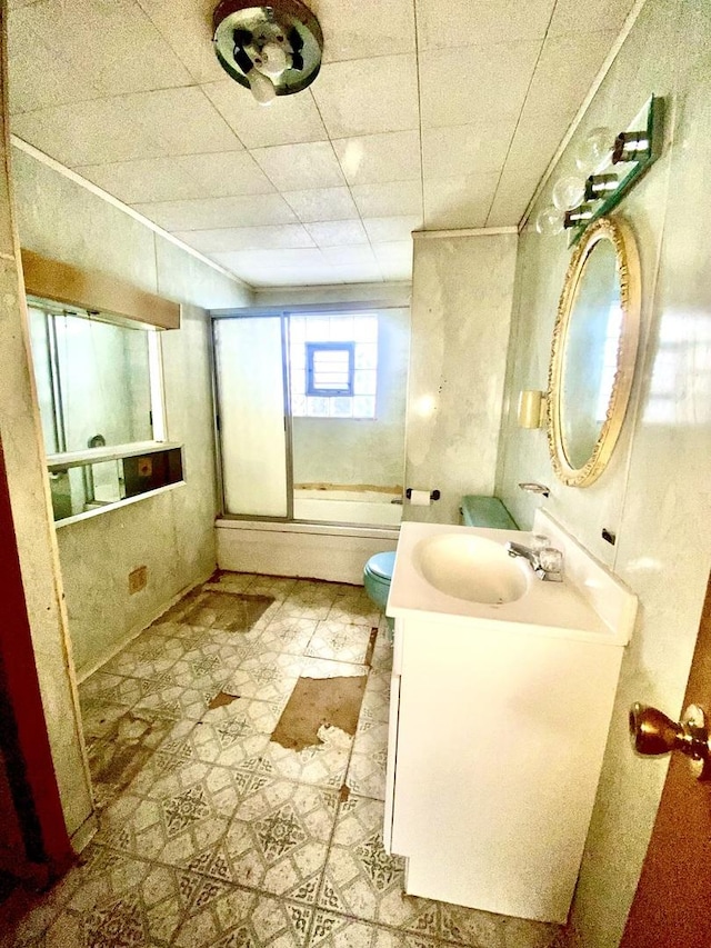 full bathroom featuring vanity, combined bath / shower with glass door, and toilet